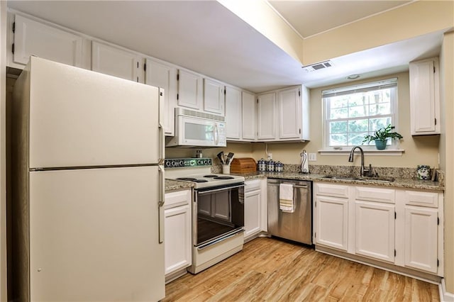 1750 Clairmont Rd Unit 35, Decatur, GA 30033 - kitchen featuring white appliances, a sink, light wood-type flooring, and white cabinets