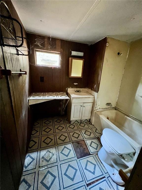 bathroom featuring wood walls, vanity, and toilet