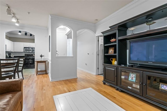 living room with arched walkways, light wood finished floors, crown molding, and baseboards