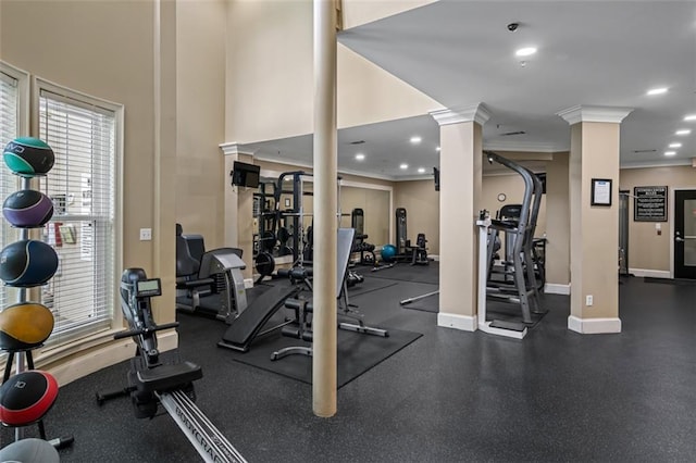gym featuring ornate columns, crown molding, and baseboards