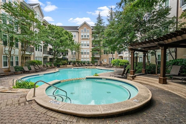 community pool with a community hot tub, a patio, and a pergola