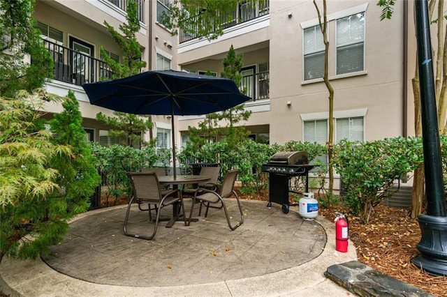 view of patio with grilling area, outdoor dining area, and a balcony