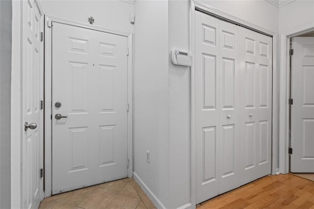 doorway to outside featuring baseboards and light tile patterned flooring