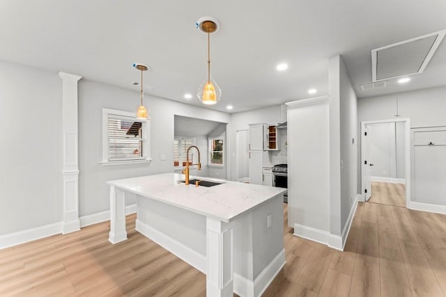 2128 Hosea L Williams Dr NE, Atlanta, GA 30317 - kitchen with light wood-style flooring, recessed lighting, light stone countertops, a center island with sink, and pendant lighting