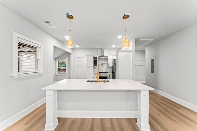 2128 Hosea L Williams Dr NE, Atlanta, GA 30317 - kitchen with wall chimney range hood, tasteful backsplash, light wood-type flooring, light stone counters, and white cabinets