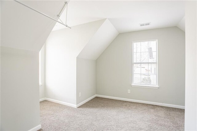 additional living space featuring visible vents, carpet, lofted ceiling, and baseboards