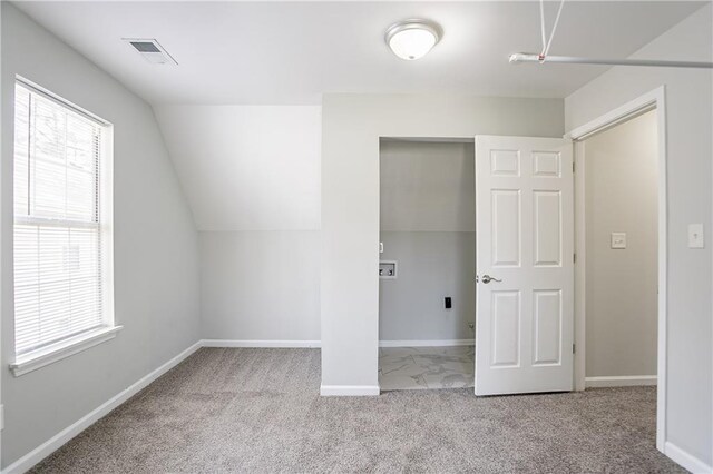 additional living space with baseboards, visible vents, vaulted ceiling, and carpet