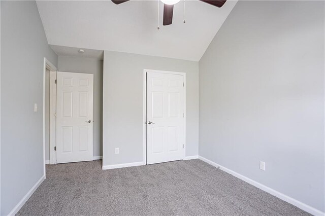 unfurnished bedroom with carpet flooring, a ceiling fan, baseboards, and lofted ceiling