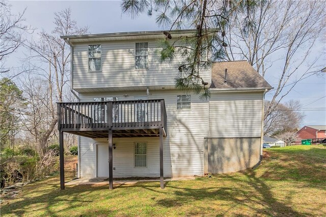 back of house featuring a wooden deck and a lawn