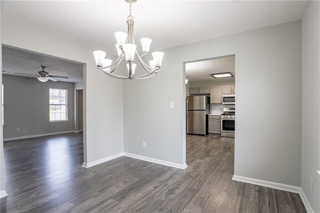 unfurnished dining area featuring baseboards, a textured ceiling, dark wood-style floors, and ceiling fan with notable chandelier