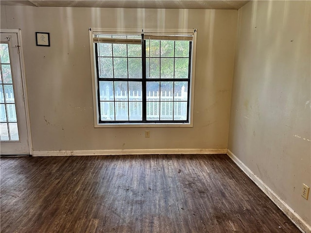 unfurnished room with dark wood-type flooring