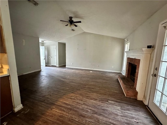 unfurnished living room featuring ceiling fan, dark hardwood / wood-style floors, vaulted ceiling, and a brick fireplace