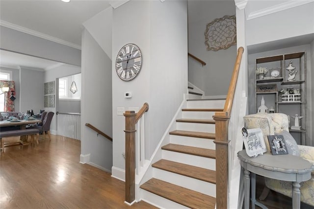 stairway featuring hardwood / wood-style flooring and crown molding