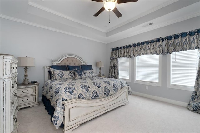 carpeted bedroom featuring a raised ceiling, crown molding, and ceiling fan