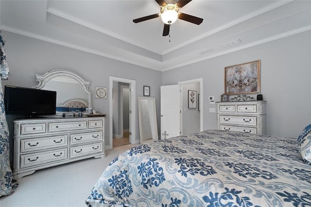 bedroom featuring light carpet, a tray ceiling, ornamental molding, and ceiling fan