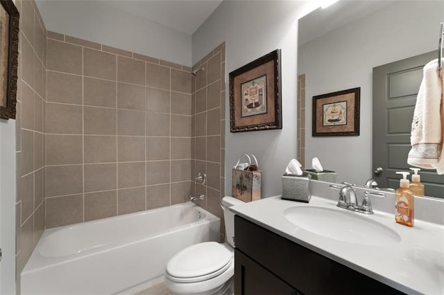 full bathroom featuring tiled shower / bath, vanity, and toilet