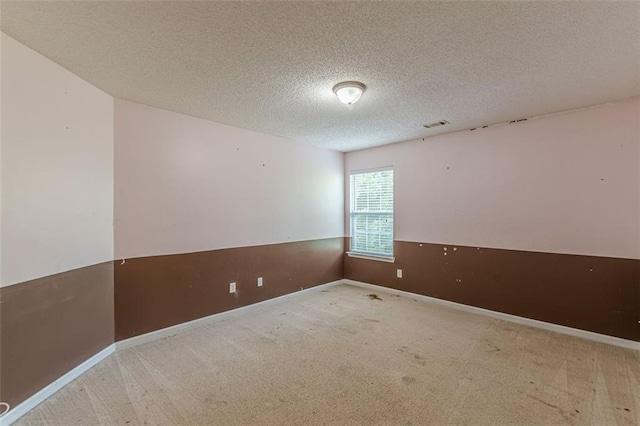 carpeted spare room with a textured ceiling