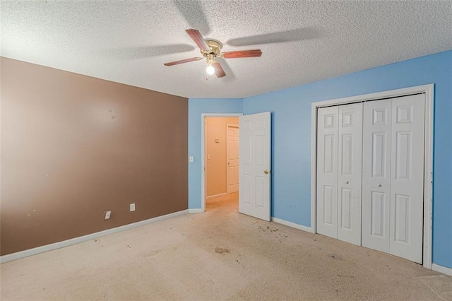 unfurnished bedroom featuring ceiling fan, a textured ceiling, light carpet, and a closet