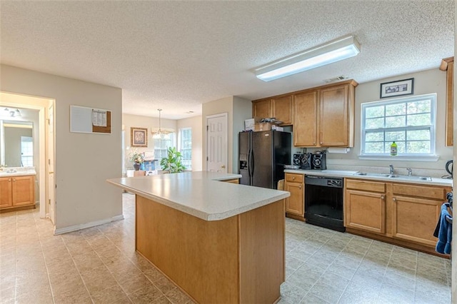 kitchen featuring a healthy amount of sunlight, pendant lighting, a kitchen island, and black appliances