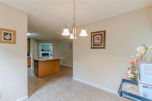 kitchen with kitchen peninsula, a kitchen island, a chandelier, and decorative light fixtures