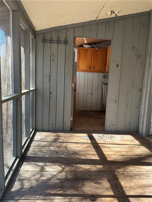 exterior space featuring wooden walls and light hardwood / wood-style flooring