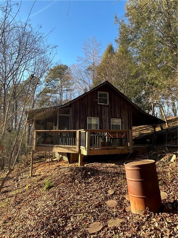 rear view of property with a wooden deck and a sunroom