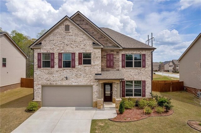 509 Azalea Bloom Dr, Loganville, GA 30052 - view of front facade with fence, concrete driveway, a front lawn, and brick siding