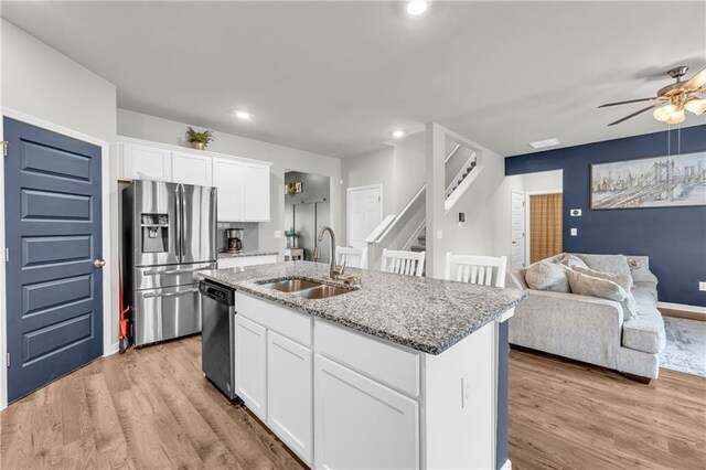 509 Azalea Bloom Dr, Loganville, GA 30052 - kitchen featuring a ceiling fan, appliances with stainless steel finishes, a sink, light stone counters, and light wood-style flooring