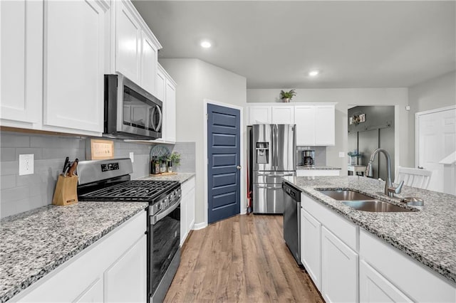 509 Azalea Bloom Dr, Loganville, GA 30052 - kitchen featuring a sink, appliances with stainless steel finishes, light wood-style floors, and white cabinetry