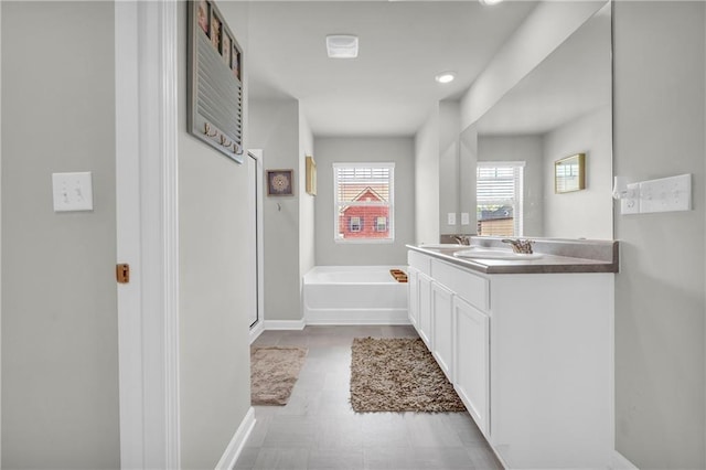 509 Azalea Bloom Dr, Loganville, GA 30052 - full bathroom featuring vanity, recessed lighting, baseboards, and a bath