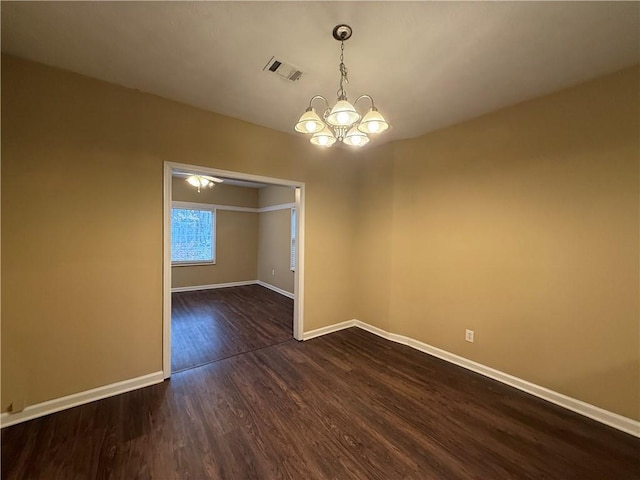 unfurnished dining area with a notable chandelier, dark wood finished floors, visible vents, and baseboards