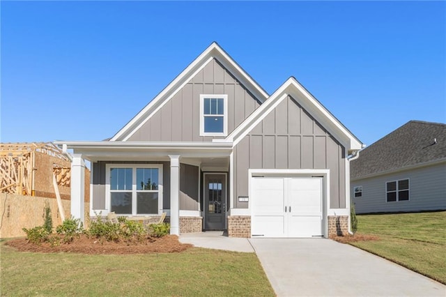 view of front of property featuring a garage, brick siding, concrete driveway, board and batten siding, and a front yard