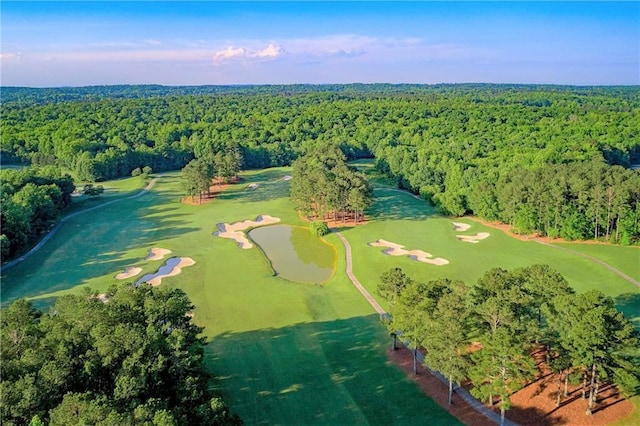 birds eye view of property with a wooded view and golf course view