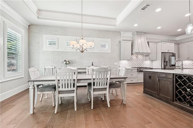 4025 Connolly Ct, Roswell, GA 30075 - dining space with a chandelier, a tray ceiling, light wood-type flooring, ornamental molding, and baseboards