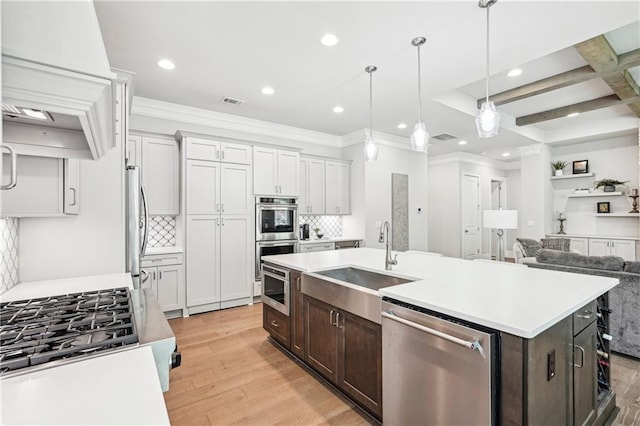 4025 Connolly Ct, Roswell, GA 30075 - kitchen with appliances with stainless steel finishes, a sink, dark brown cabinetry, light wood-style floors, and light countertops