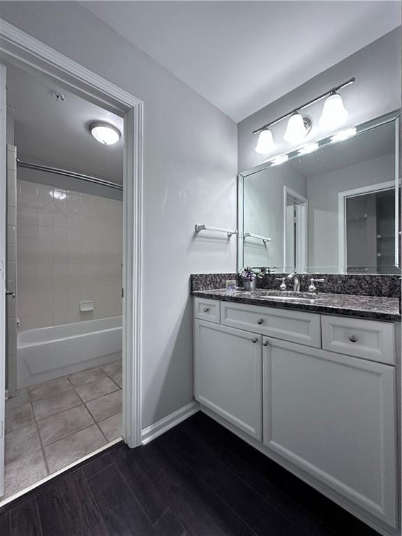 bathroom with vanity, tiled shower / bath combo, and hardwood / wood-style flooring