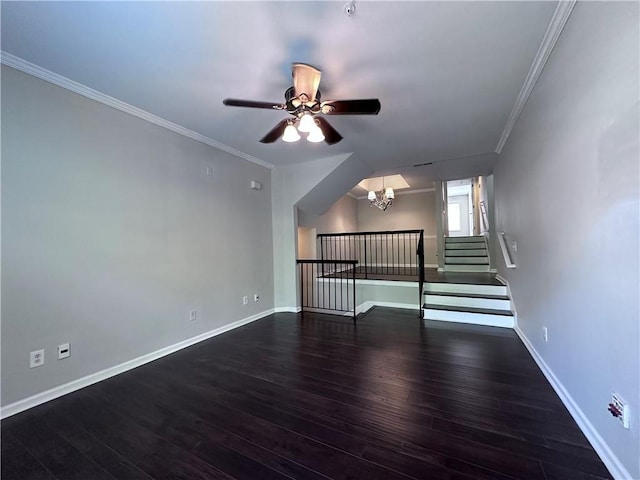 unfurnished living room featuring crown molding, ceiling fan with notable chandelier, and dark hardwood / wood-style flooring