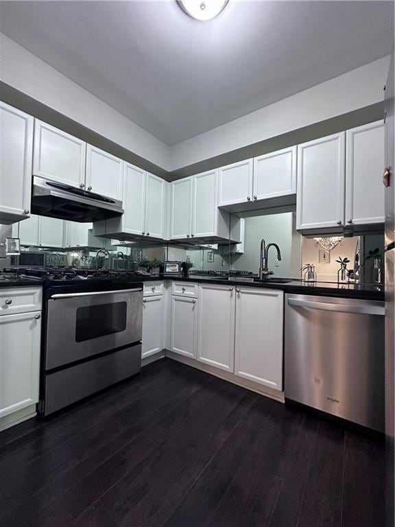 4244 River Green Dr NW Unit 111, Atlanta, GA 30327 - kitchen featuring under cabinet range hood, white cabinetry, dark countertops, and appliances with stainless steel finishes