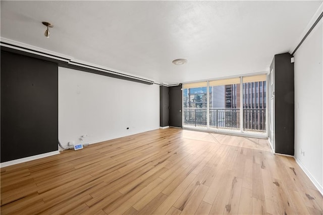 unfurnished living room with light hardwood / wood-style floors and expansive windows