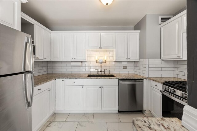 kitchen featuring white cabinets, dishwasher, and tasteful backsplash