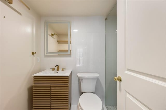 bathroom with toilet, vanity, and tile walls