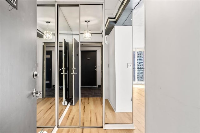 hallway with an inviting chandelier and hardwood / wood-style flooring