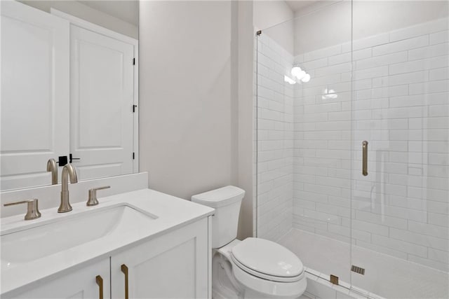 bathroom featuring vanity, toilet, and a shower with door