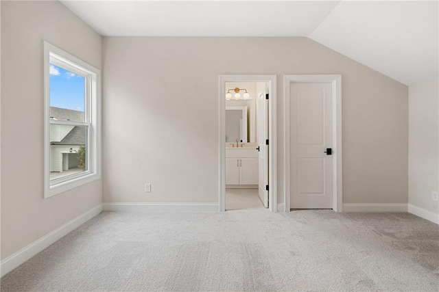 interior space featuring light colored carpet and lofted ceiling