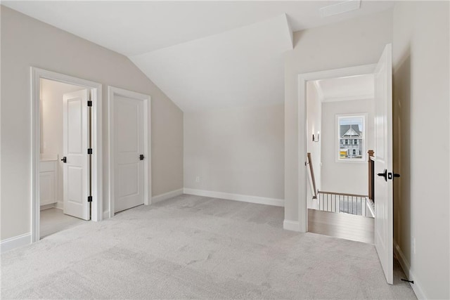 additional living space with light colored carpet and vaulted ceiling