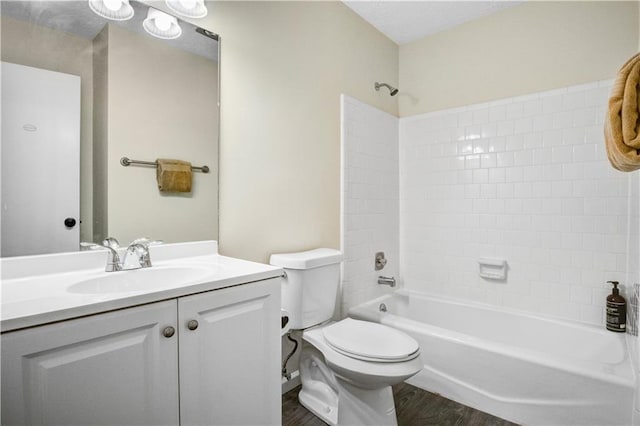 full bathroom with tub / shower combination, vanity, hardwood / wood-style floors, and toilet