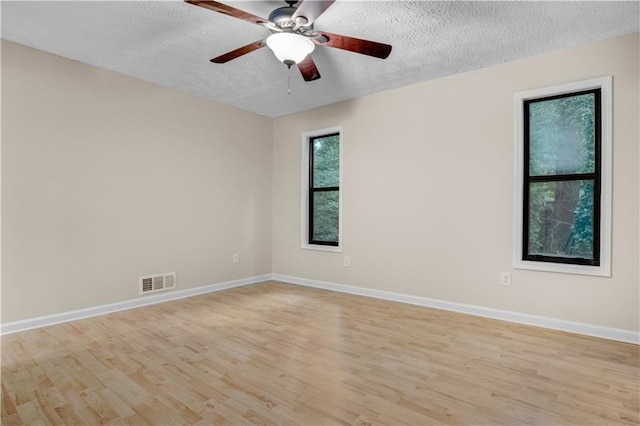 empty room with ceiling fan, a textured ceiling, and light hardwood / wood-style flooring