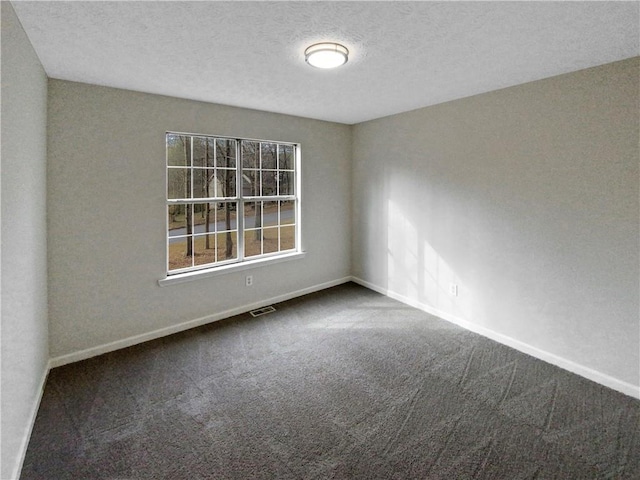 carpeted spare room with visible vents, baseboards, and a textured ceiling