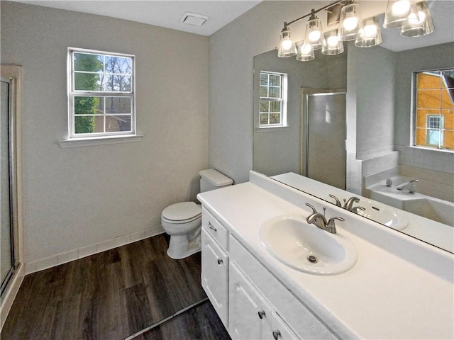 full bath with vanity, wood finished floors, baseboards, a stall shower, and toilet