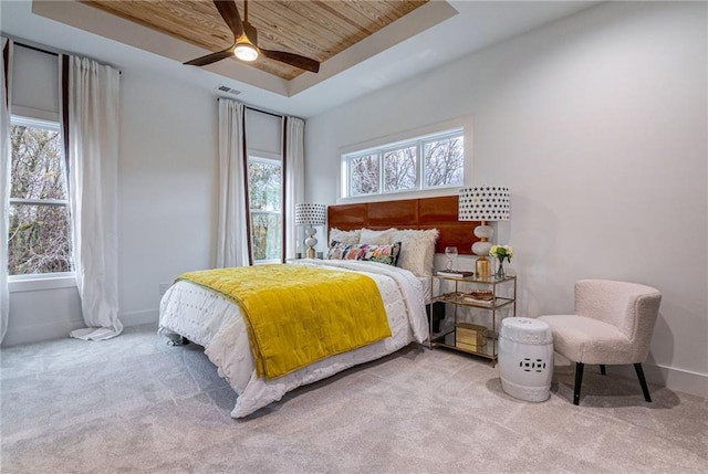 bedroom with light colored carpet, wooden ceiling, a raised ceiling, and ceiling fan